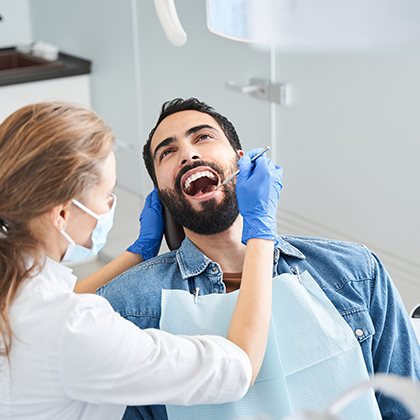 man in dentists chair mouth open during procedure
