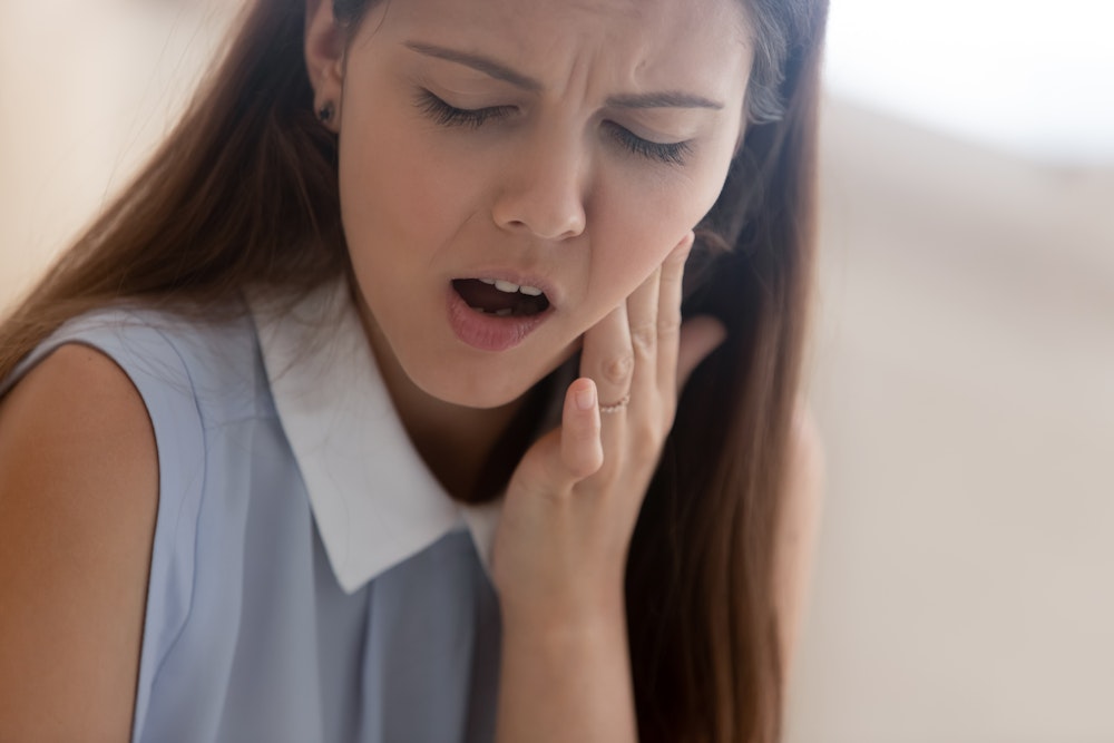 Woman holding jaw in pain