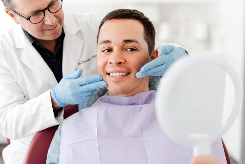 Dentist with patient looking in the mirror