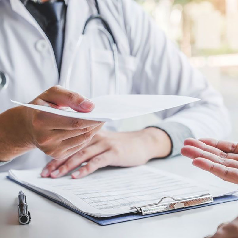 Doctor handing over paper to patient