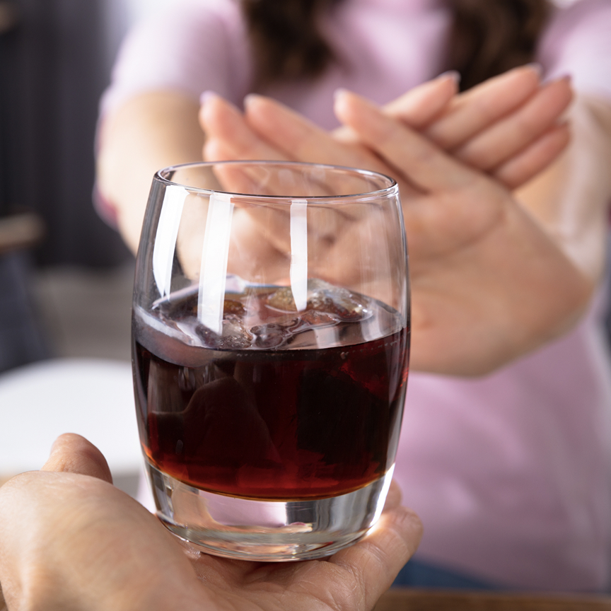 Woman saying no to a glass of wine