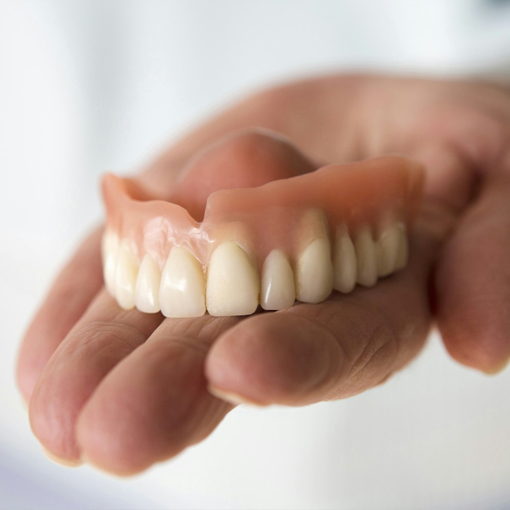 Denture in hand