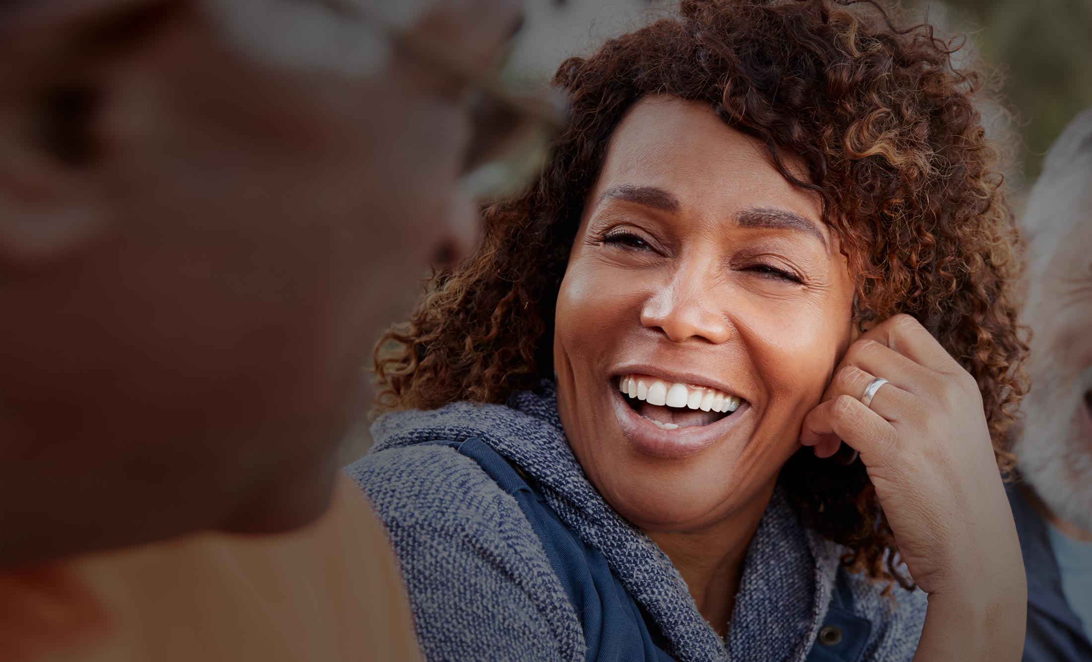 Older woman with curly white hair smiling