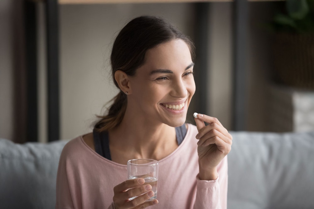 Woman taking sedative pill before dental appointment