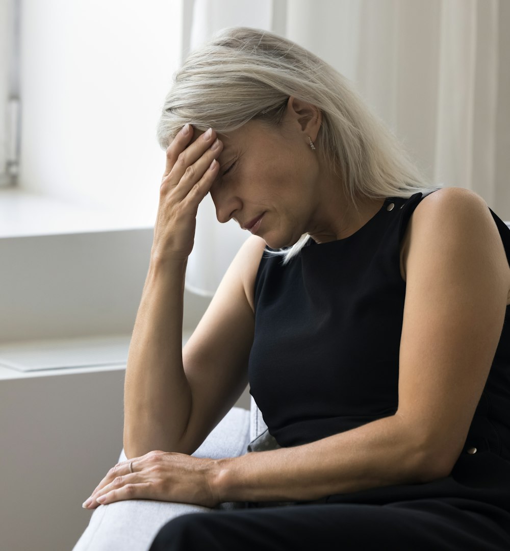 Woman sitting on the couch with a headache