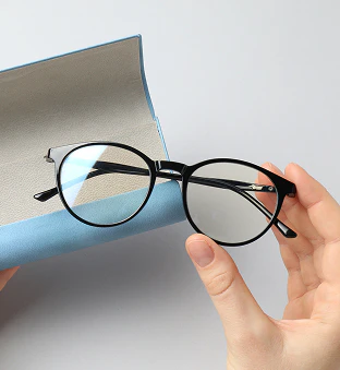 Hand holding a pair of eyeglasses