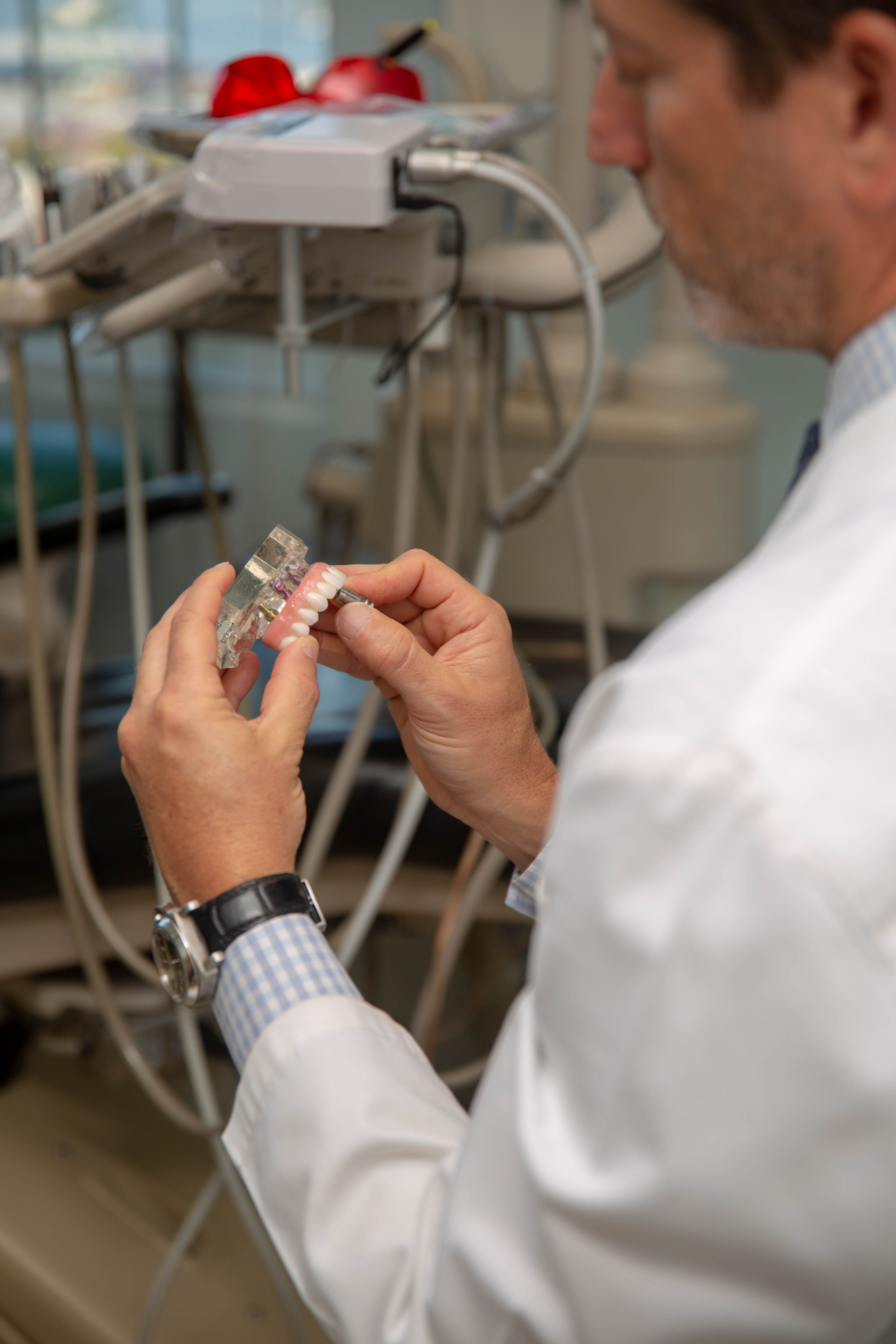 Dr. adjusting dental implants denture on a model