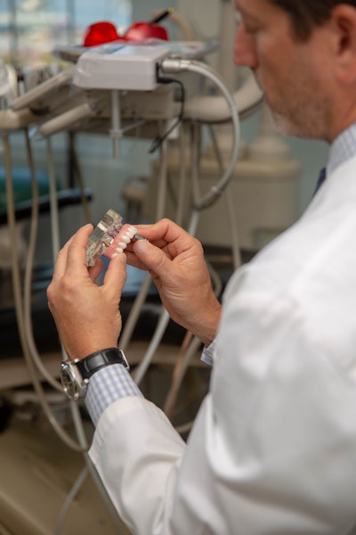 Dr. adjusting dental implants denture on a model