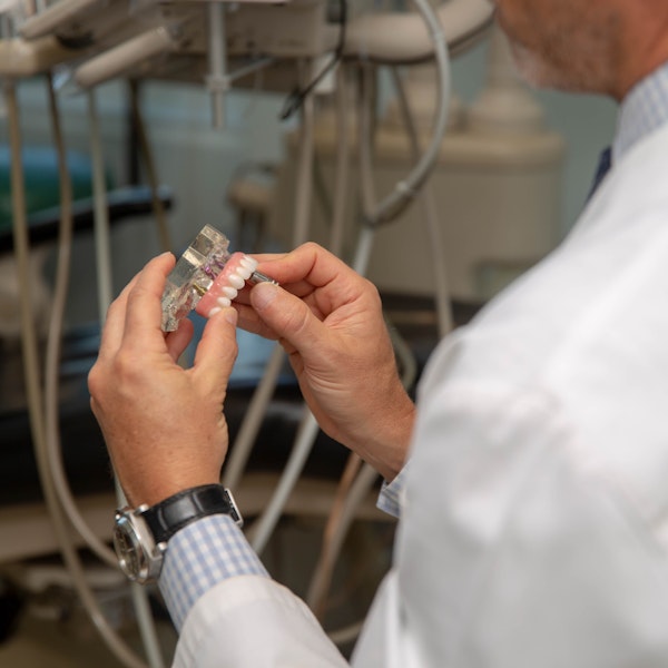 Dr. adjusting dental implants denture on a model