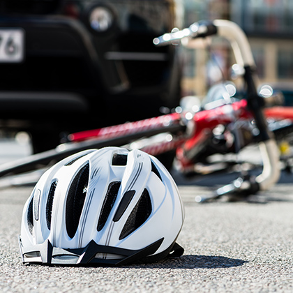 Bicycle helmet and bike on the pavement