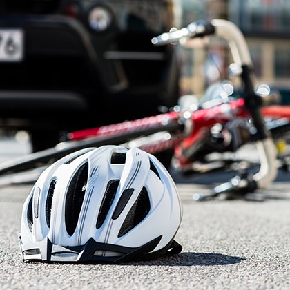 Bicycle helmet and bike on the pavement