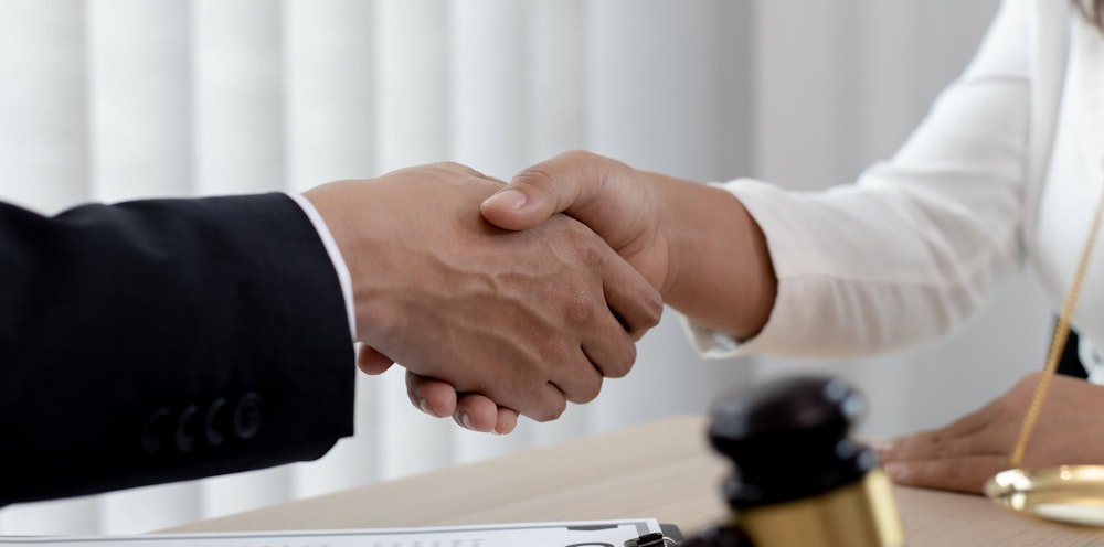 Lawyers shaking hands over settlement