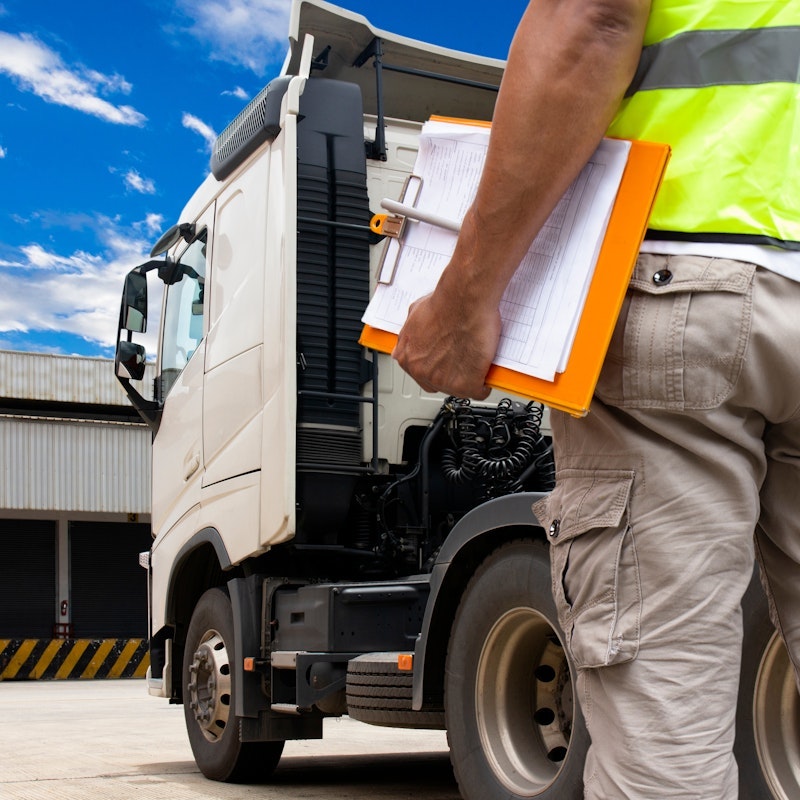 Man with a clipboard at a trucking base