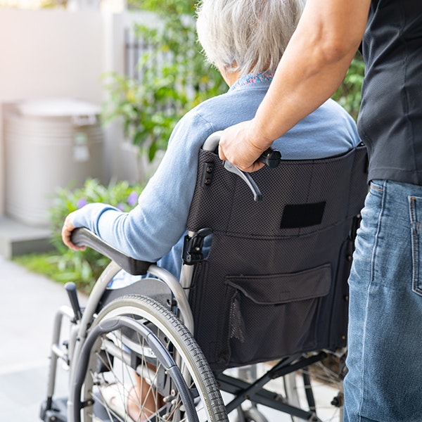 Man in wheelchair being pushed