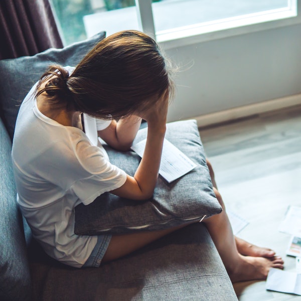 Woman upset looking over her stack of medical bills