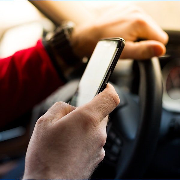 a person texting on a phone while driving