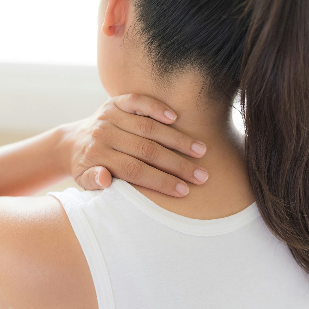 a woman rubbing her neck