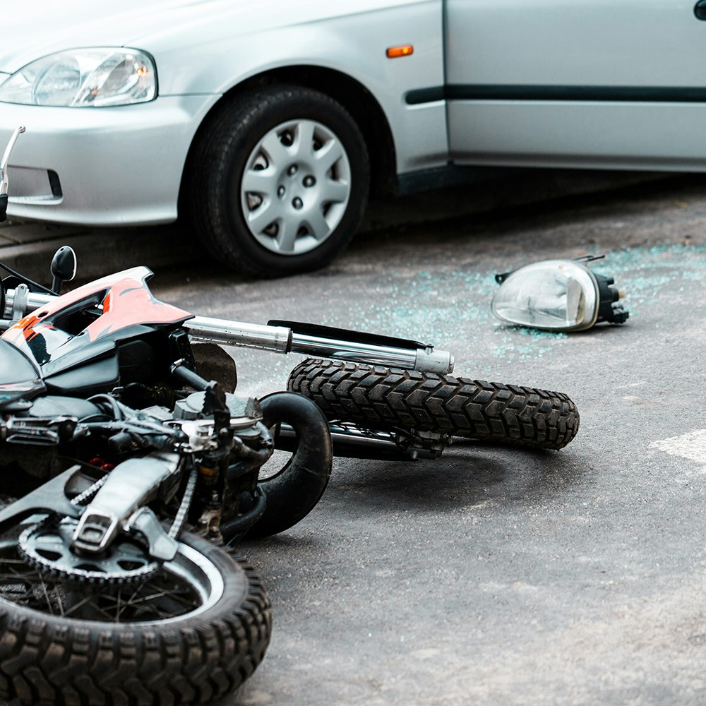 a motorcycle laying next to a car