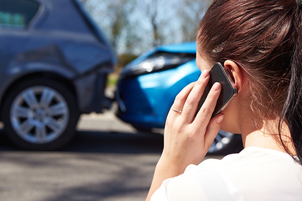 a woman making a phone call from the scene of a car accident