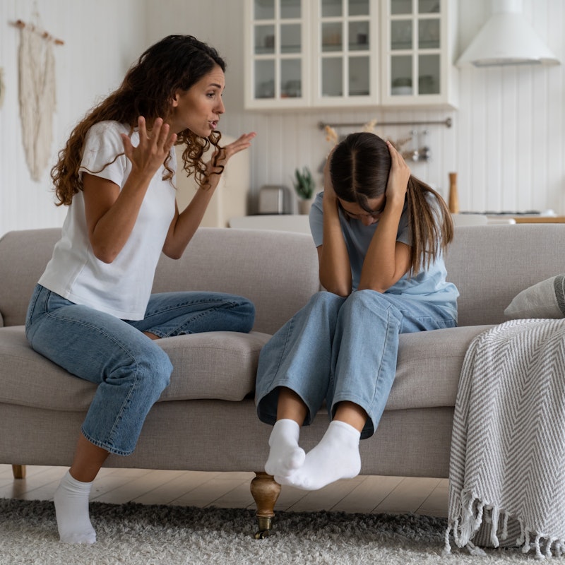 Angry mother shouting at her daughter who is covering her ears