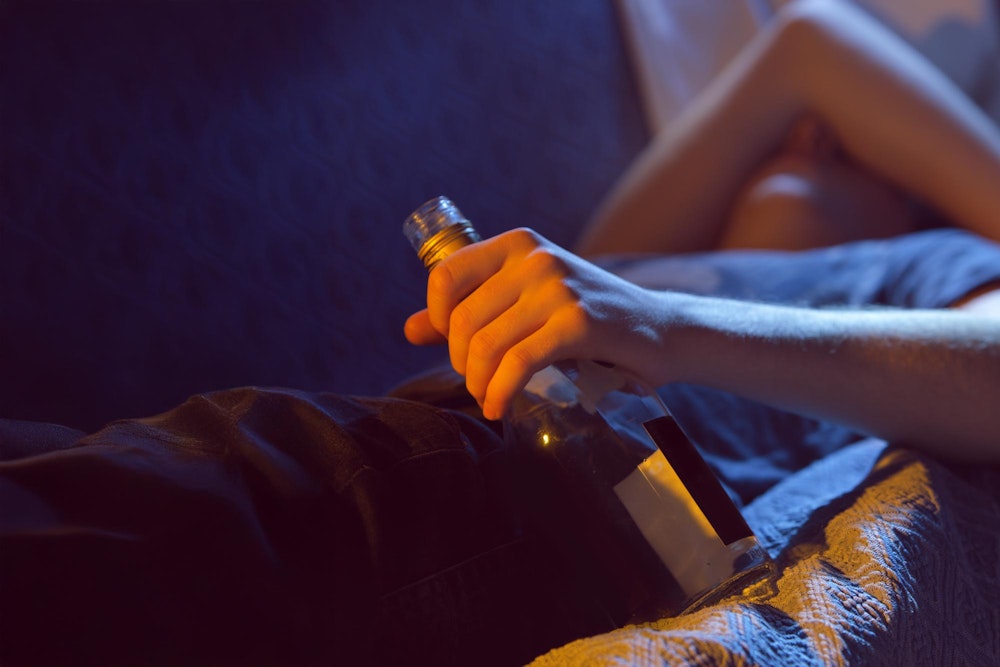 Teen holding a bottle of alcohol