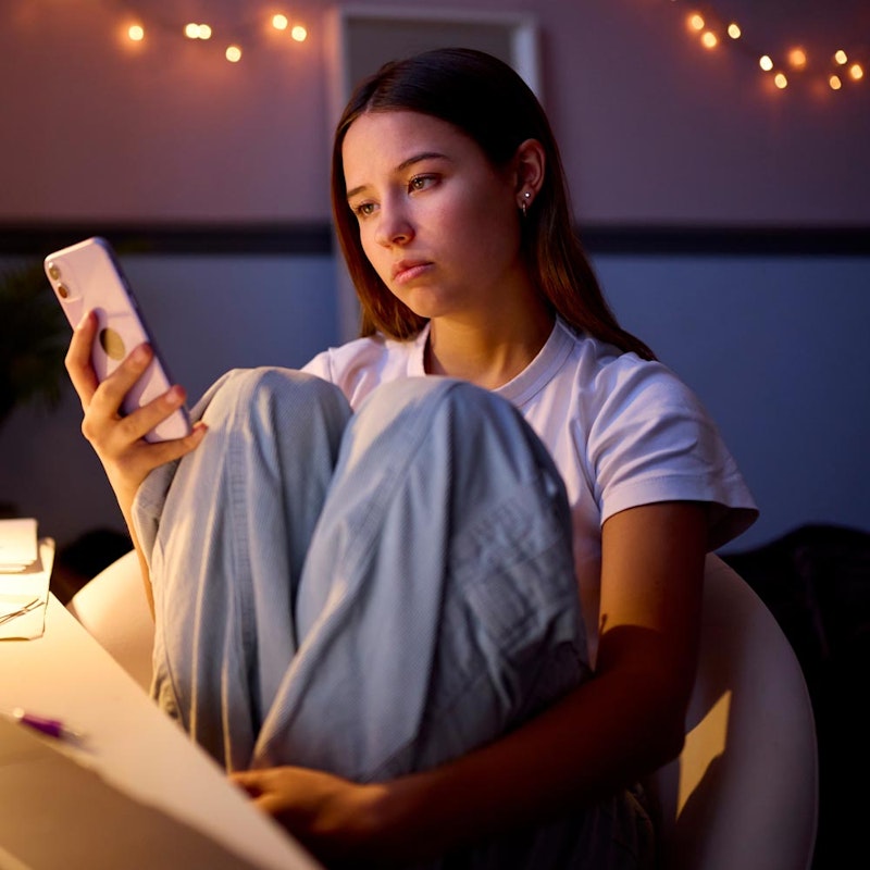 Teenage girl thinking about making a phone call