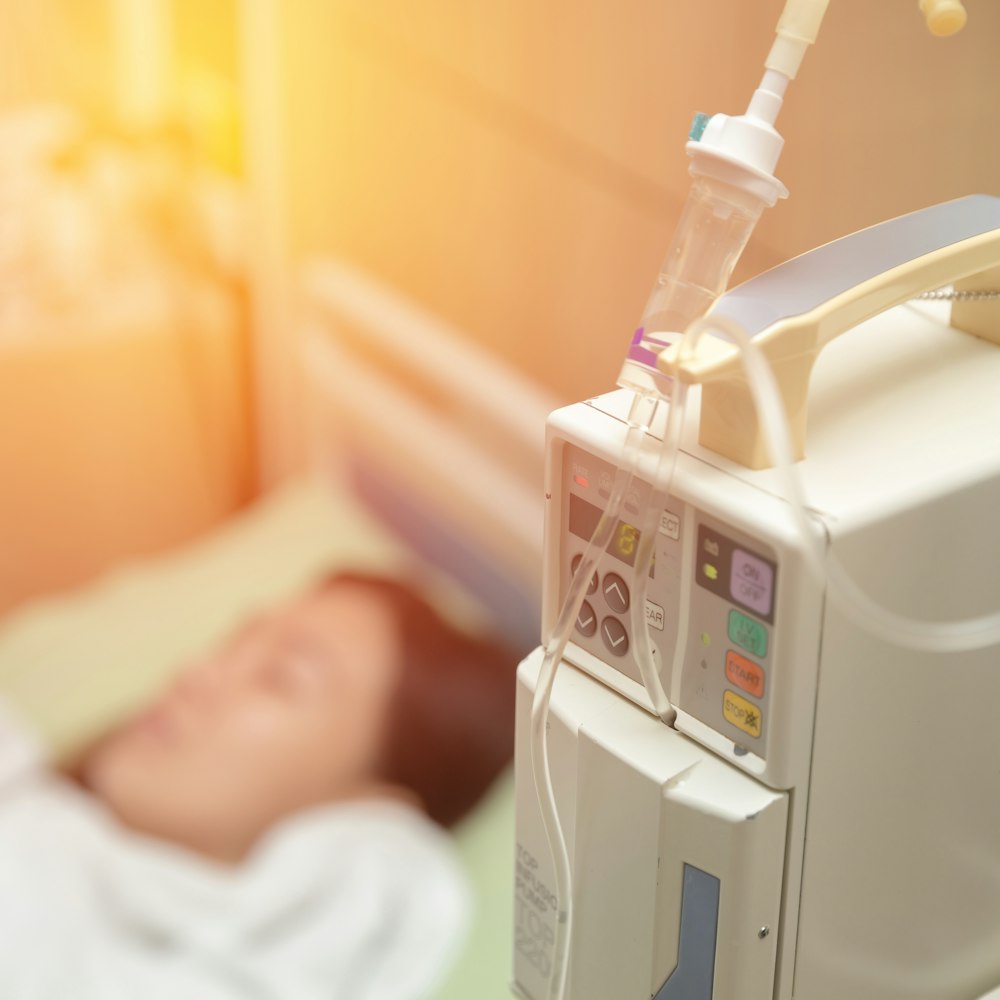 Blurred woman lying in hospital bed and receiving IV