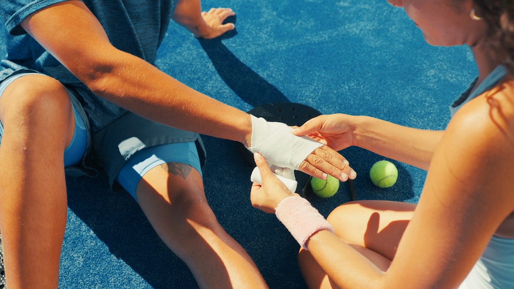 Referees attending to basketball player laying on court