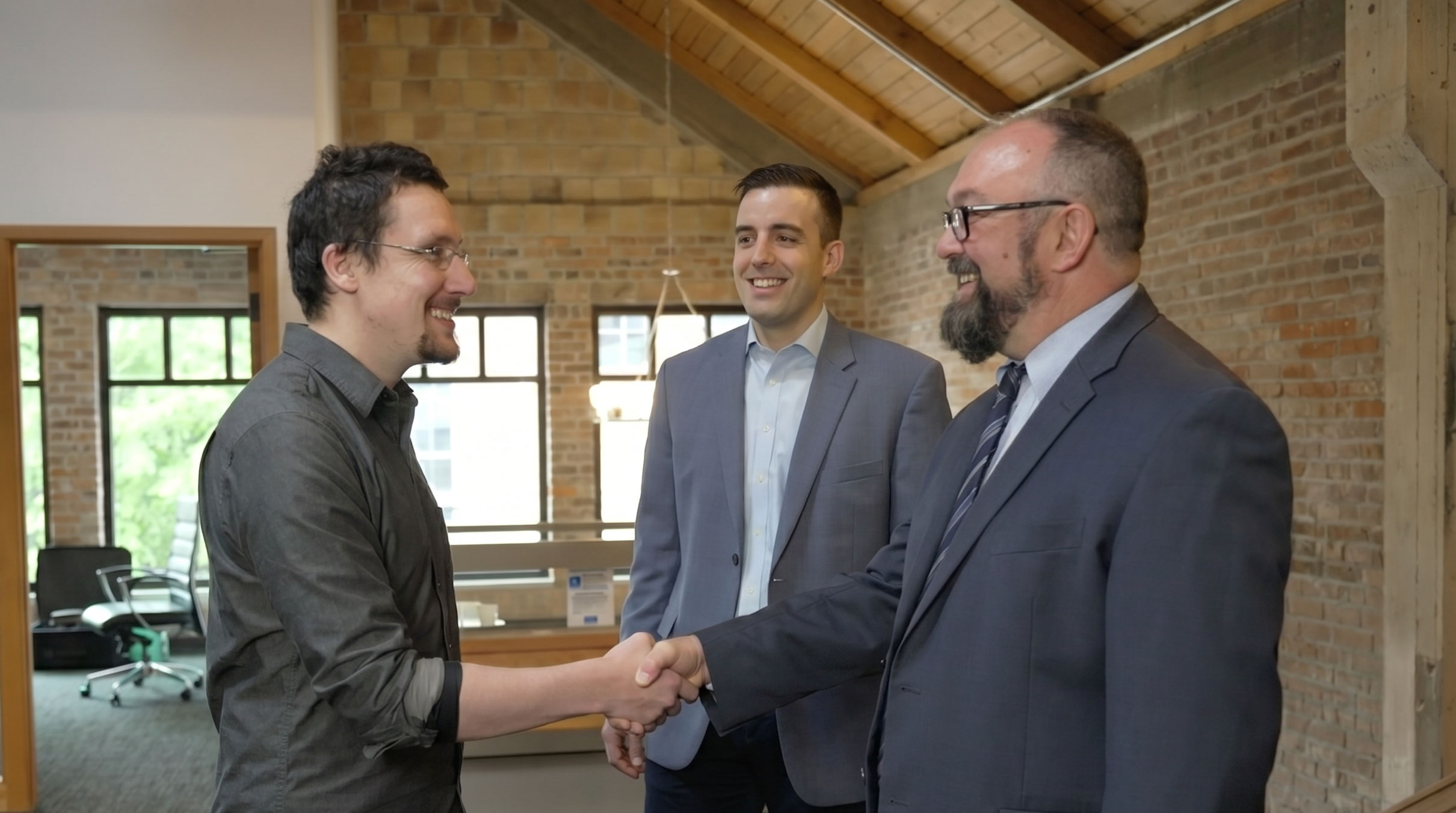 Loren Cochran shaking hands with client as he and Cole Douglas provide a warm welcome to their Washington office
