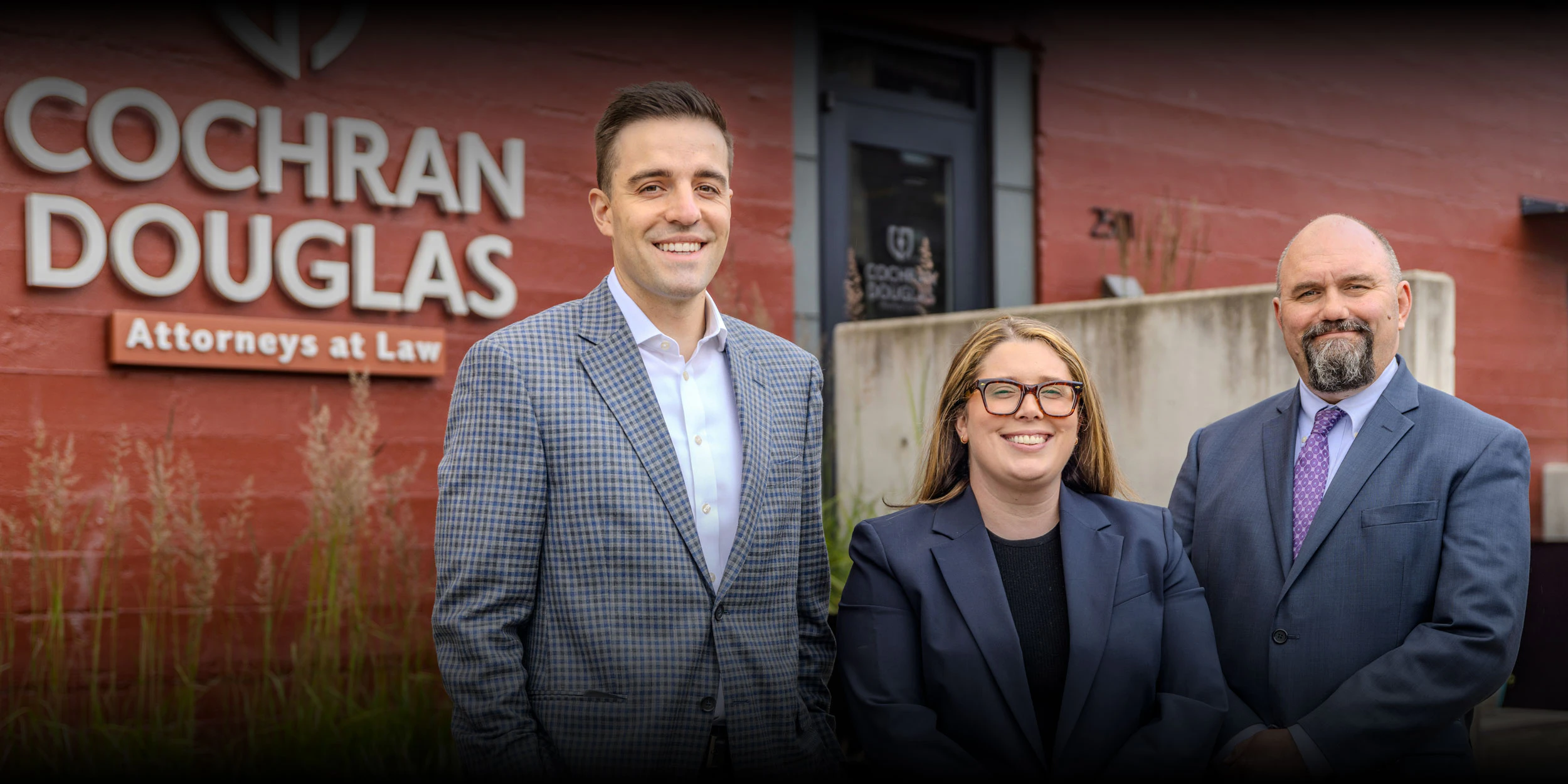 Cole Douglas, Tiffany Wilke, and Loren Cochran Attorneys at Law posing in front of their Washington office