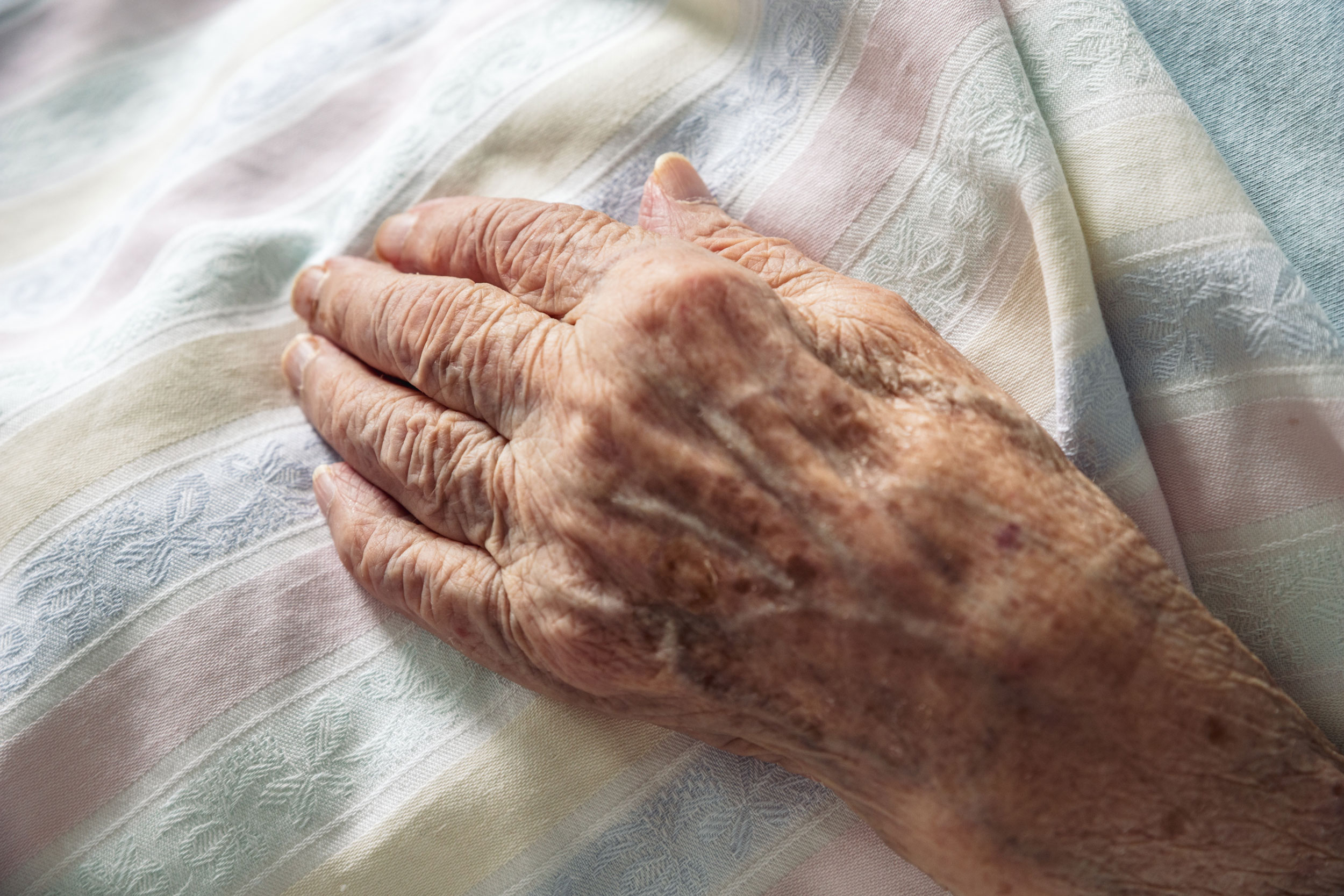 a senior's hand on blanket in Vancouver Washington