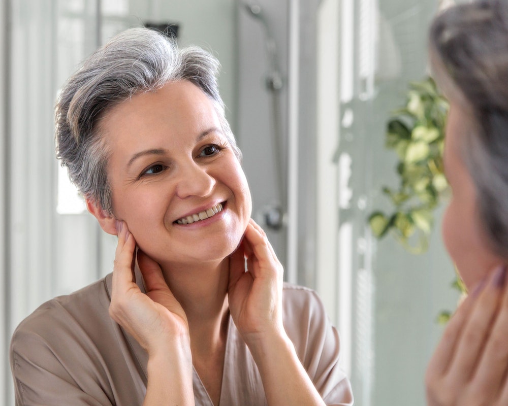 woman admiring her face in the mirror