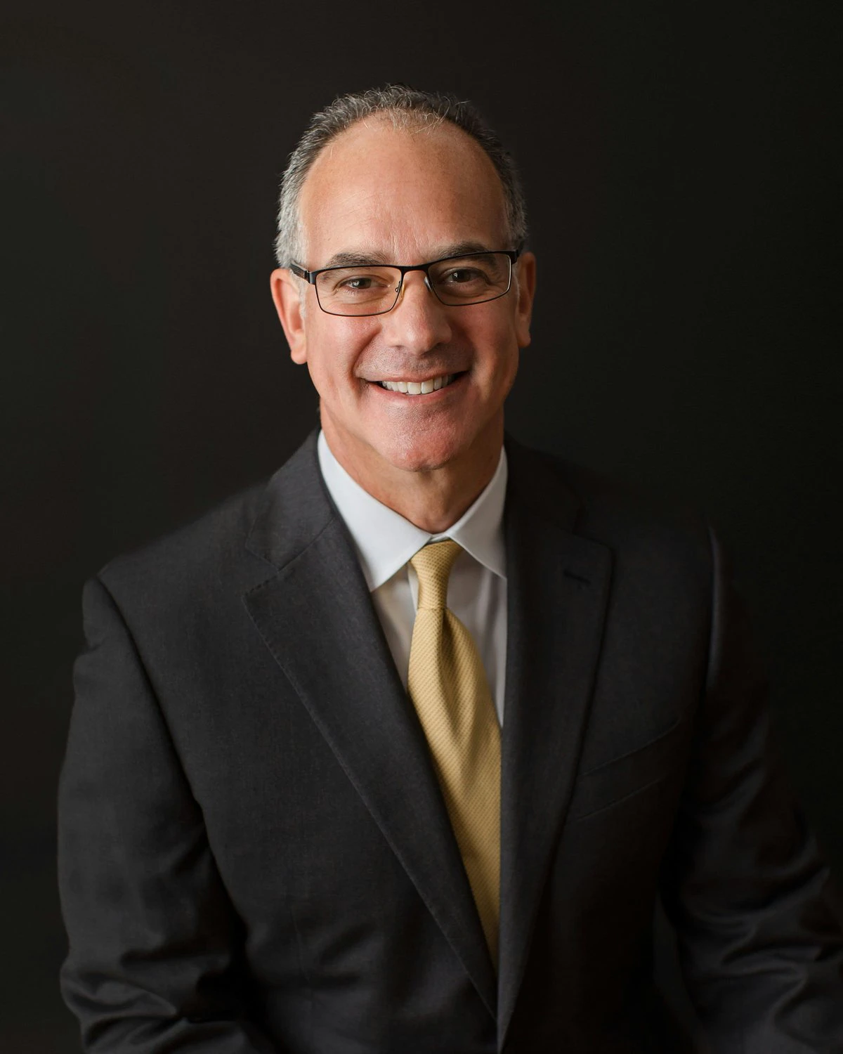 William C. Cohen in a dark suit and gold tie.