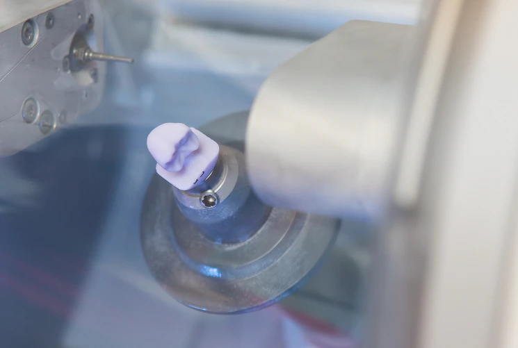close-up of a dental crown being made in a CEREC machine