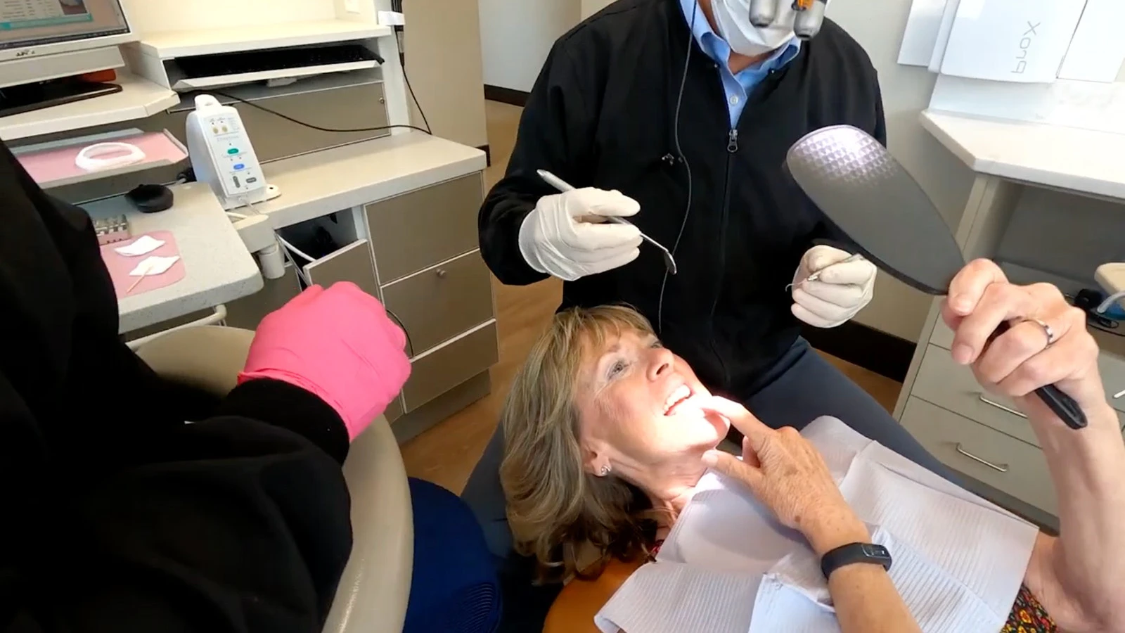 Dr. Slaman and patient checking smile in handheld mirror
