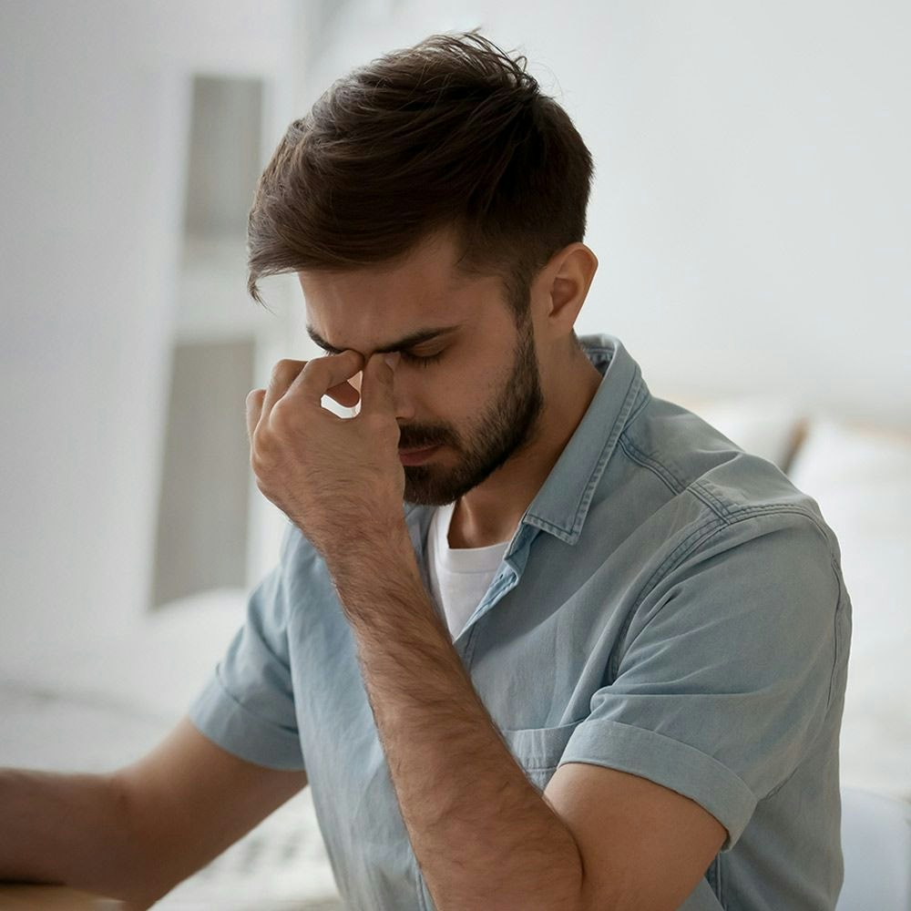 A man with itchy eyes after looking at a computer