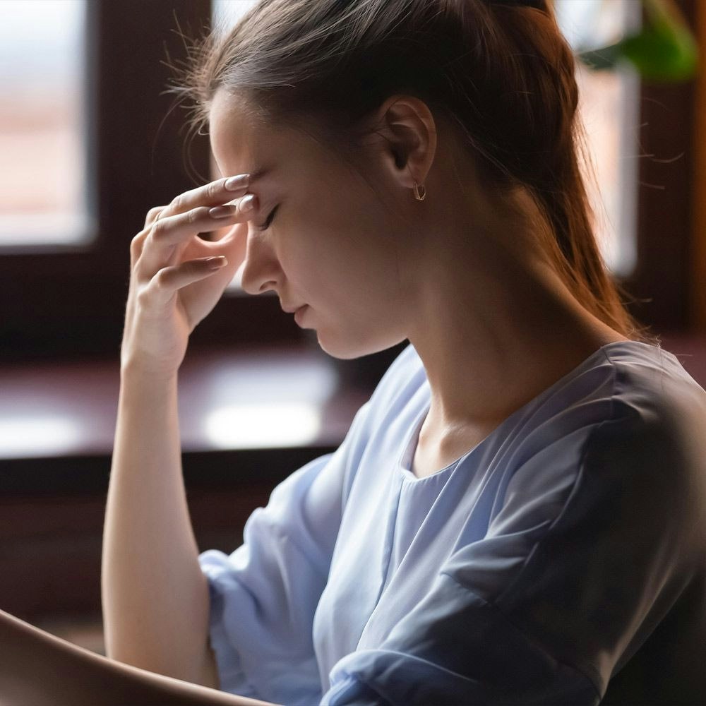 Woman touching forehead