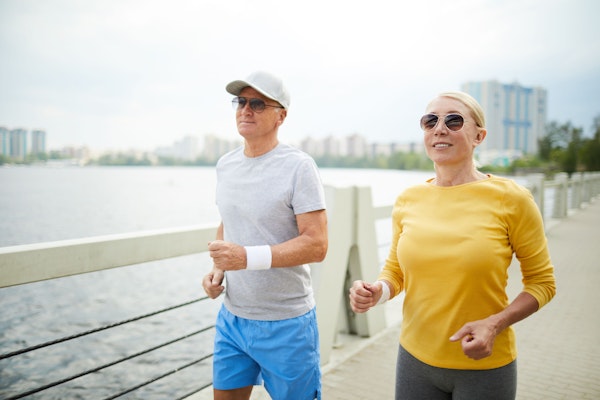 Woman wearing sunglasses running by the water