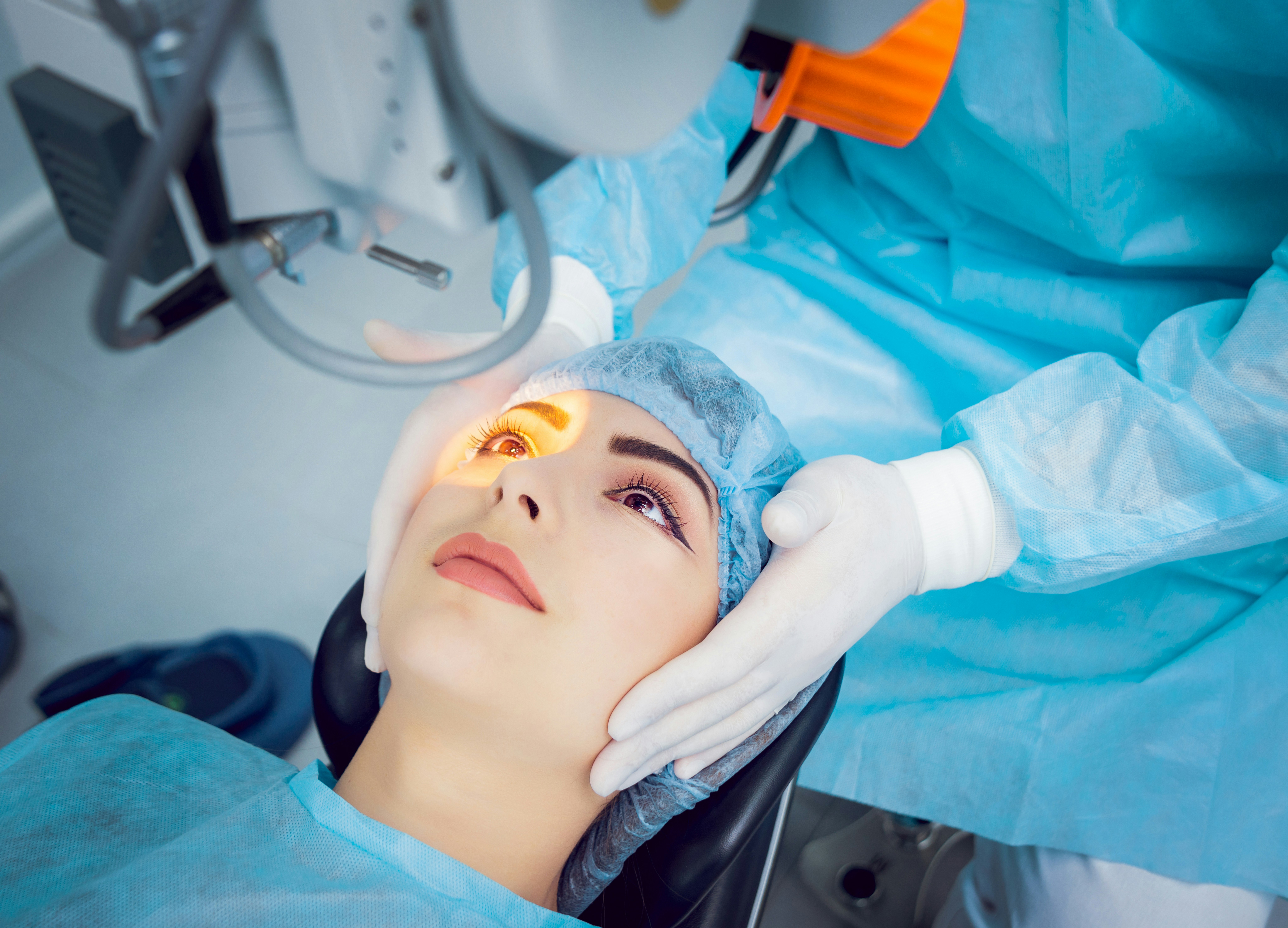 Surgeon steadying PRK patient's head during procedure