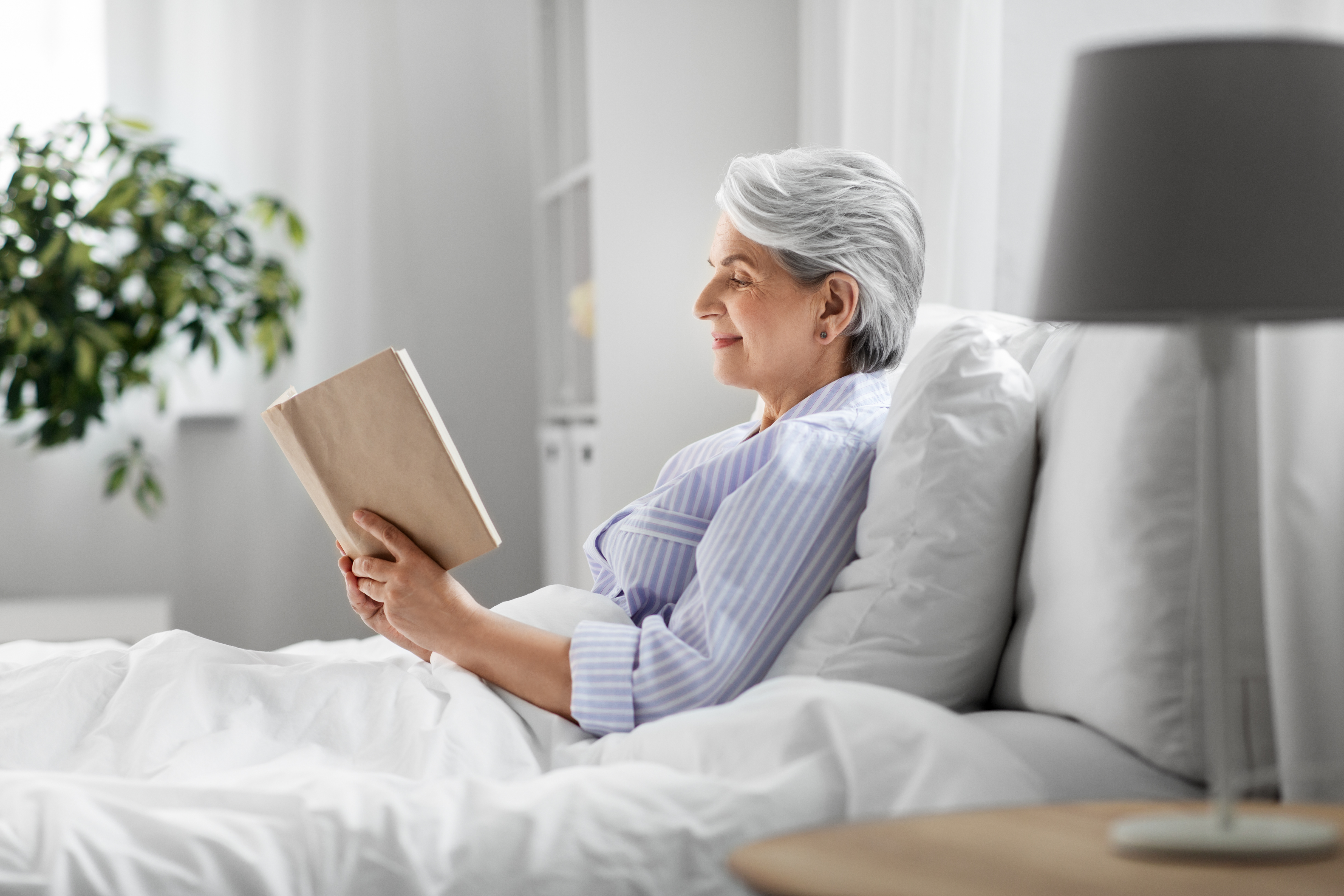 Senior woman reading in bed