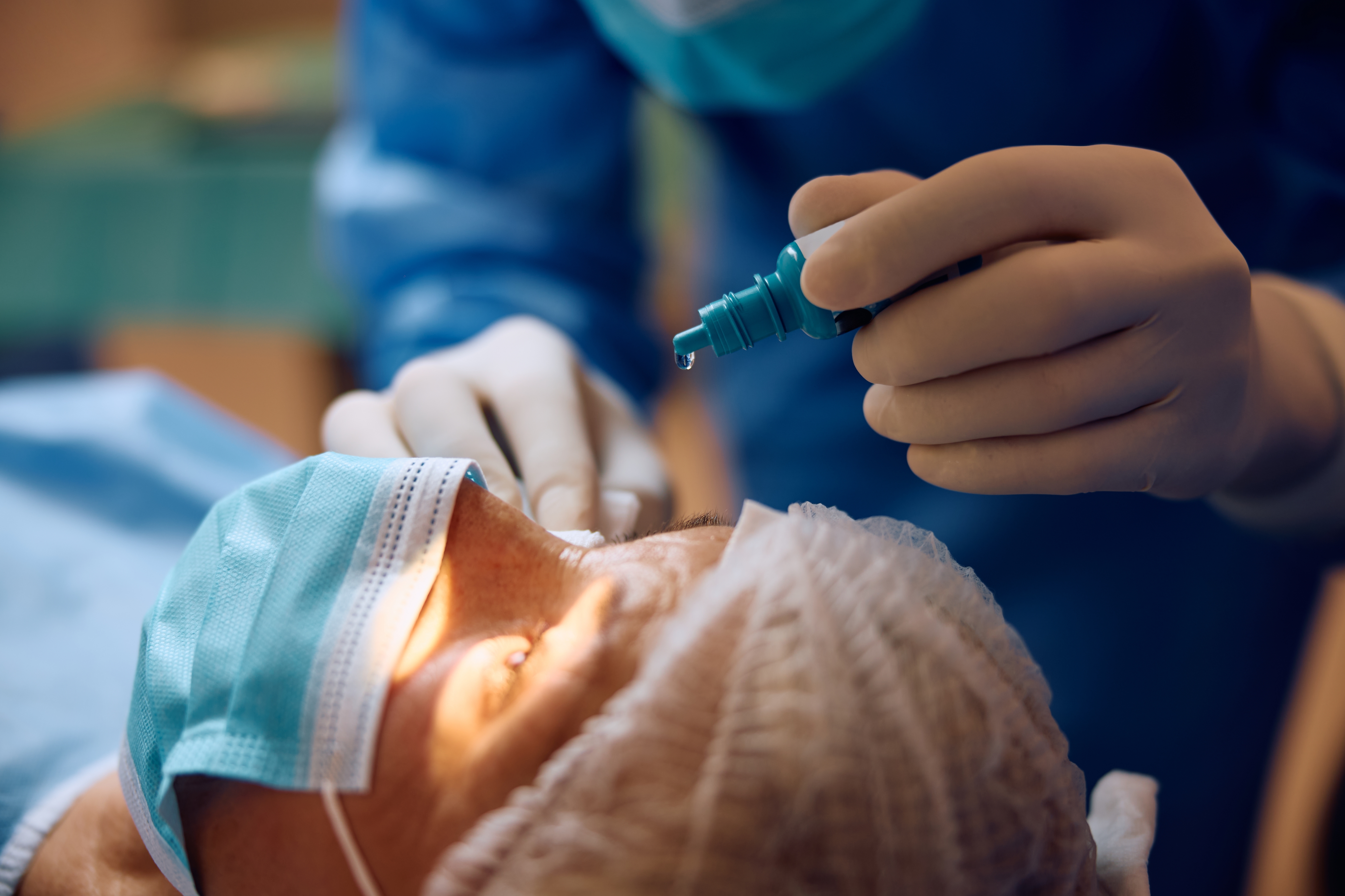Ophthalmologist administering eye drops before surgery