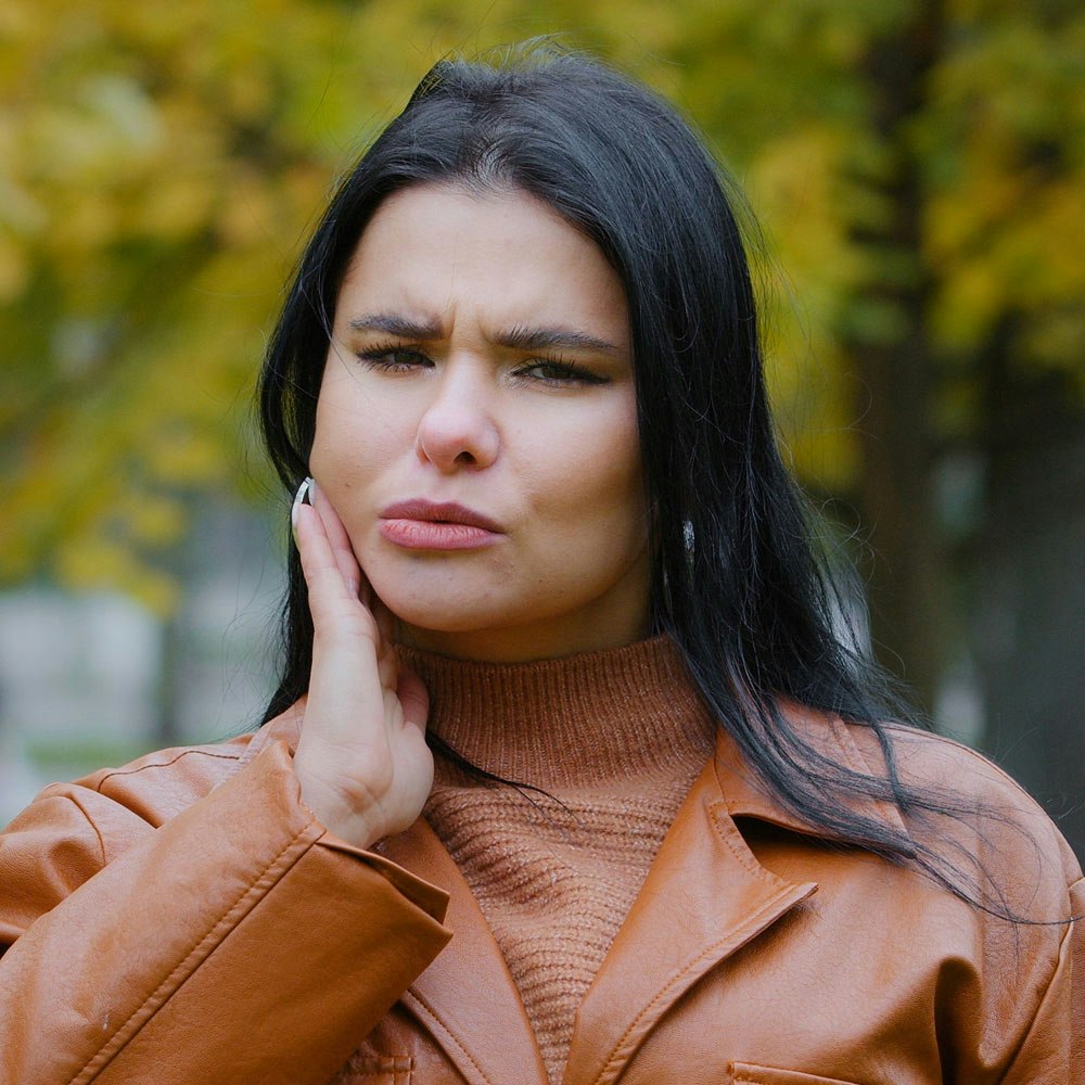 Woman holding jaw in pain