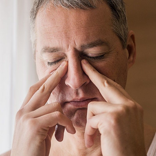 Man pinching bridge of nose