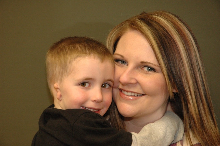 Son with misshapen ear being held by mother