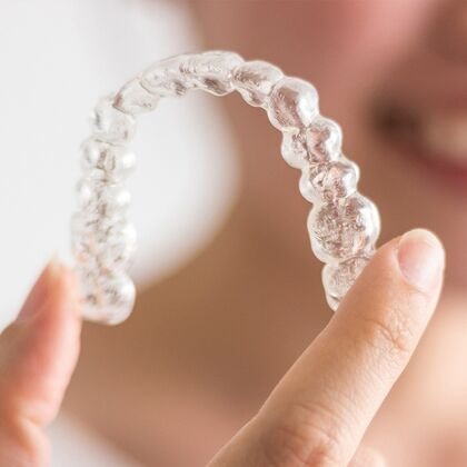 Hand holding Invisalign tray