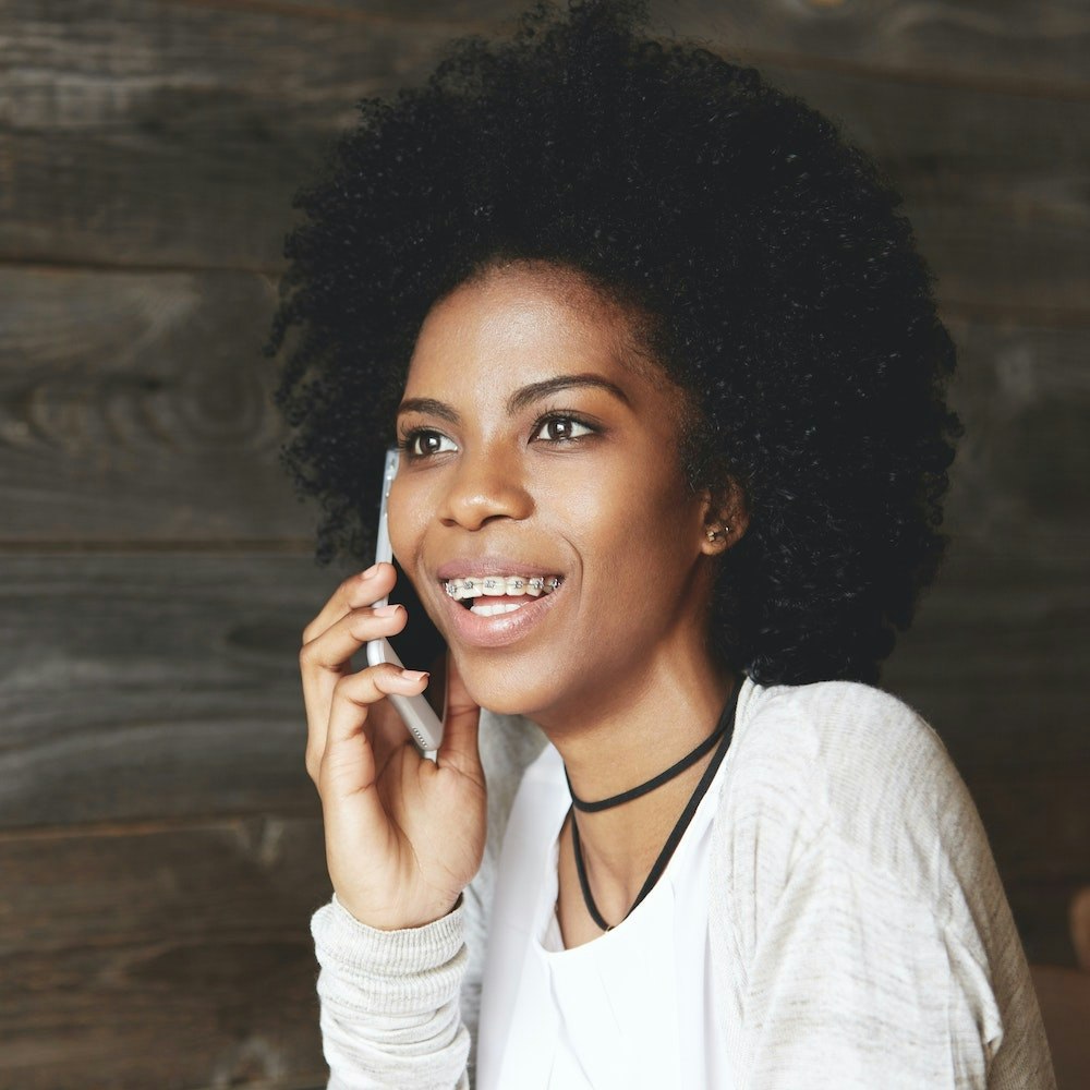 Smiling teenage girl with braces on the phone