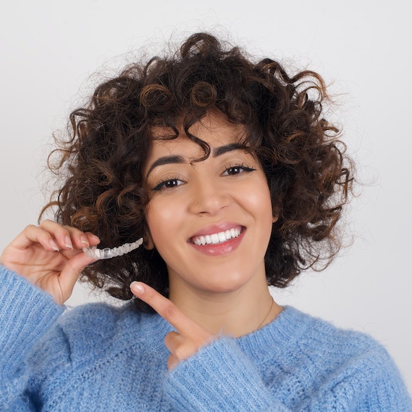 Young woman pointing to a clear aligner