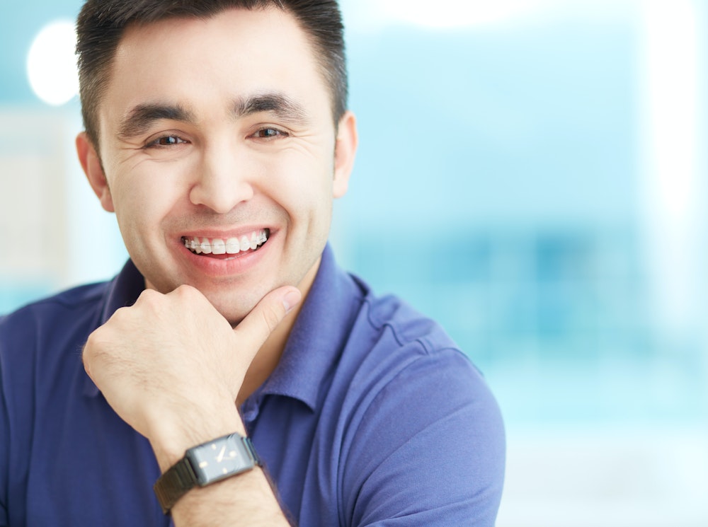 Smiling middle-aged man wearing ceramic braces