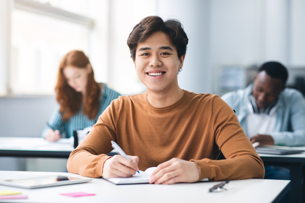Smiling teenager wearing Invisalign tray