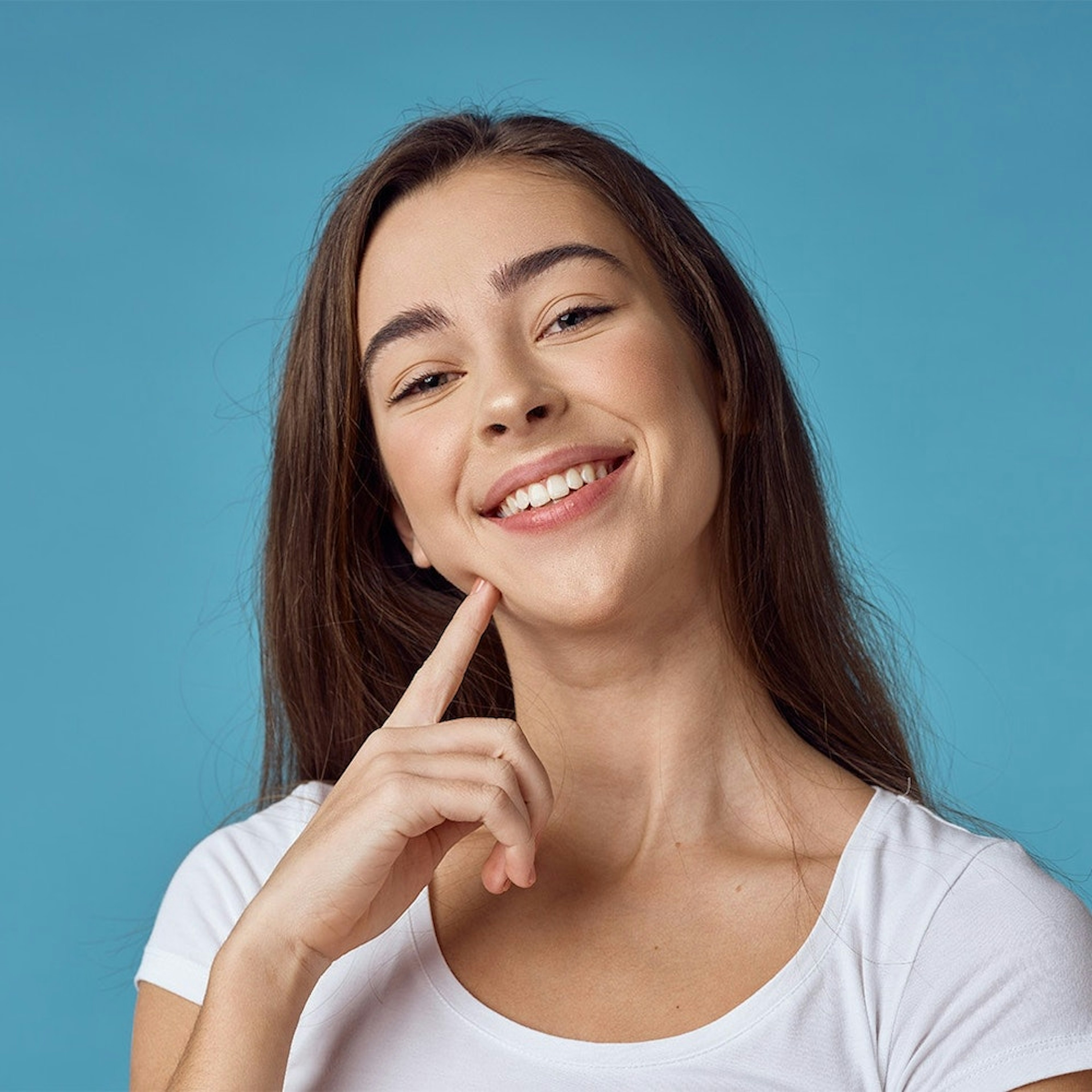 Smiling teenage girl pointing to mouth after wisdom tooth removal